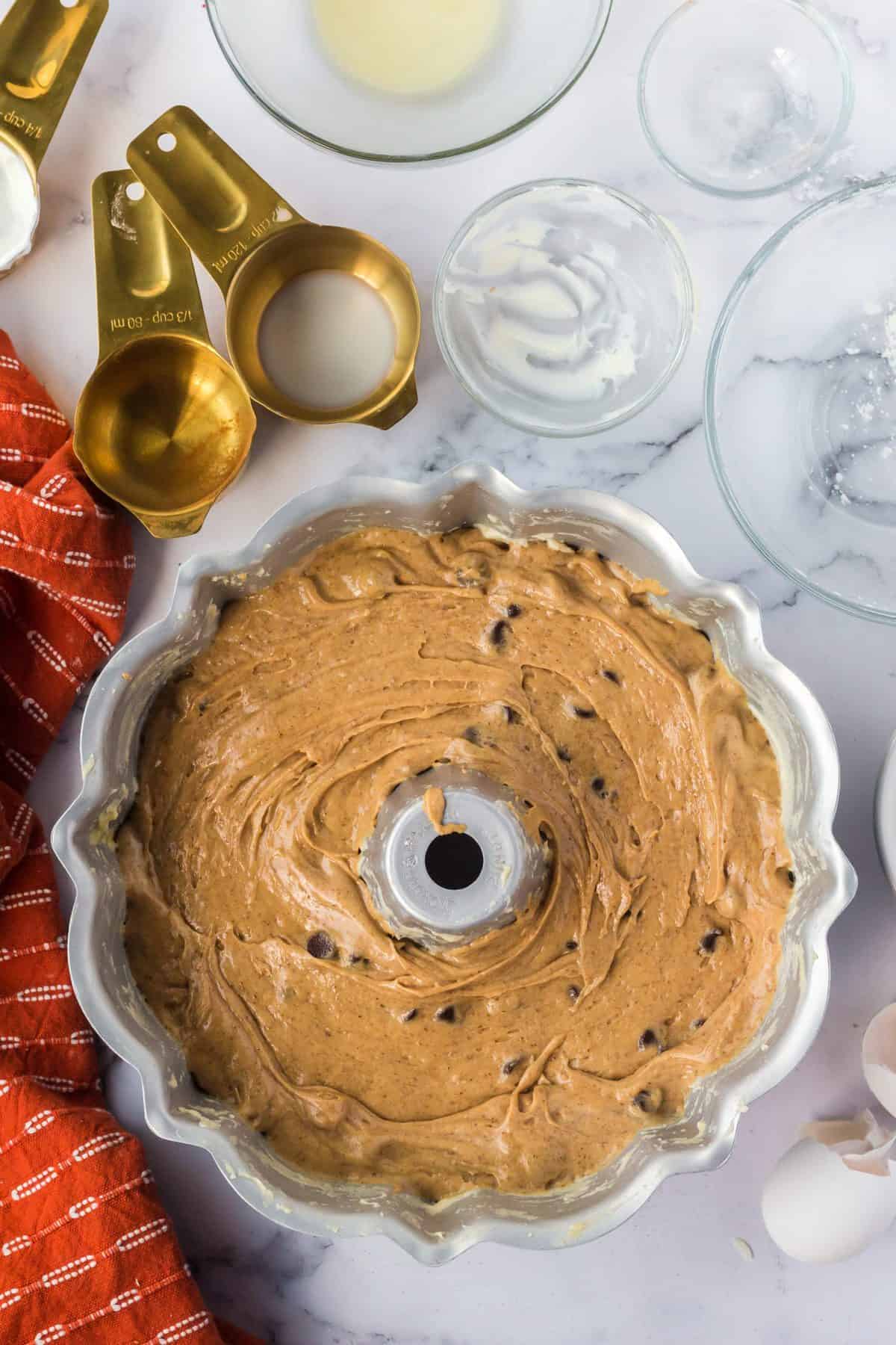 pouring the batter into the prepared bundt cake pan getting ready to bake